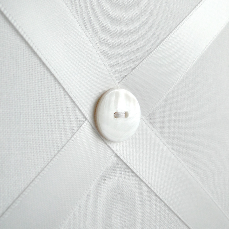 Close up of white ribbon memo board showing white button detail